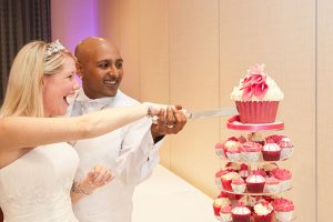 Bride and groom cut wedding cake at the Marriott Hotel in Waltham Abbey, Essex