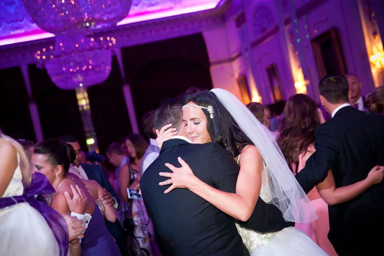 Bride and groom embracing on dancefloor during wedding reception