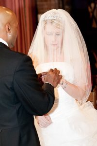 Bride and groom exchanging wedding rings at St Michael and All Angels Church, Essex